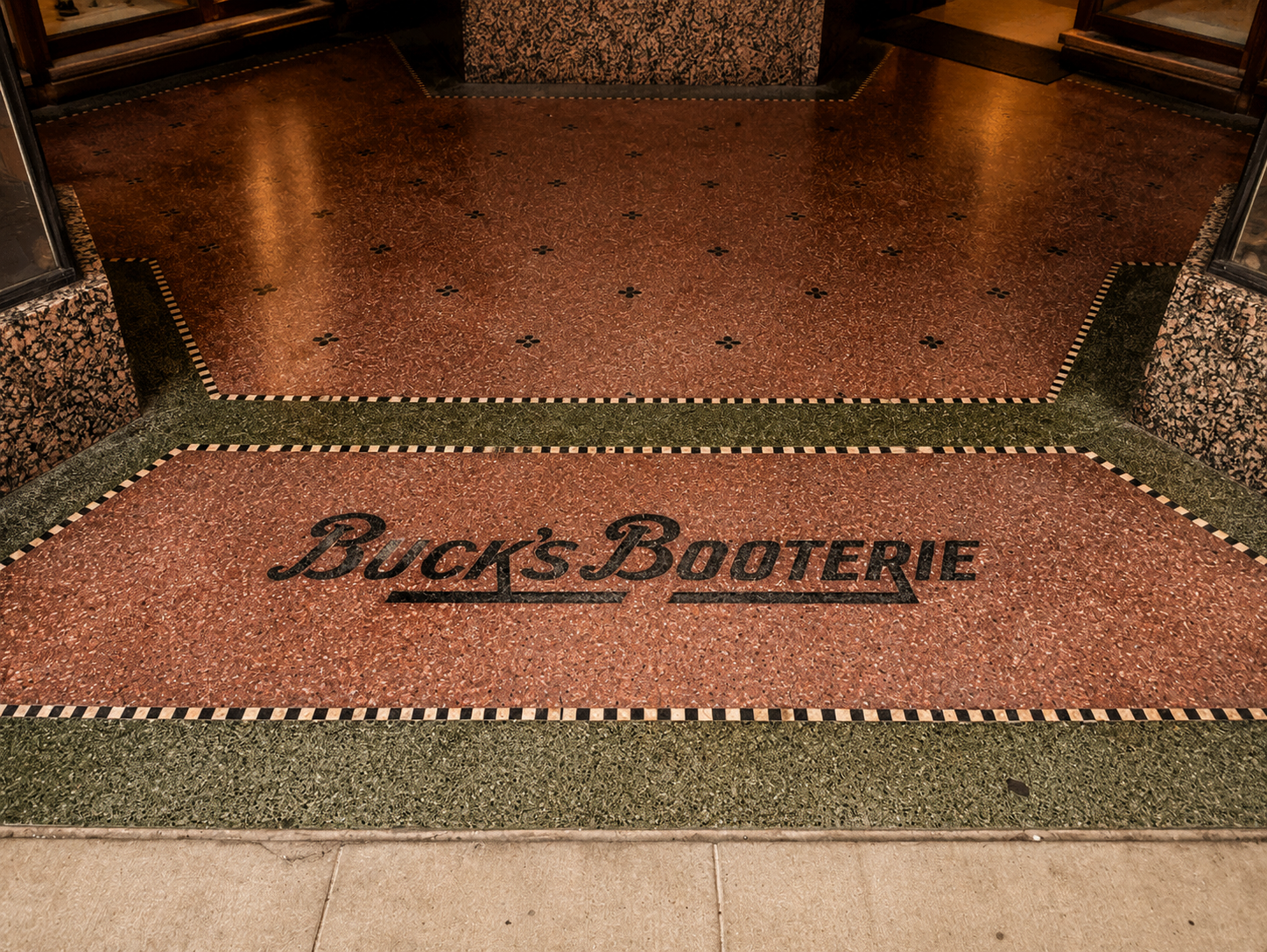 Original terrazzo entryway inlaid with the Buck's Booterie name at 1505 Farnam Street, now home to The Reading Room