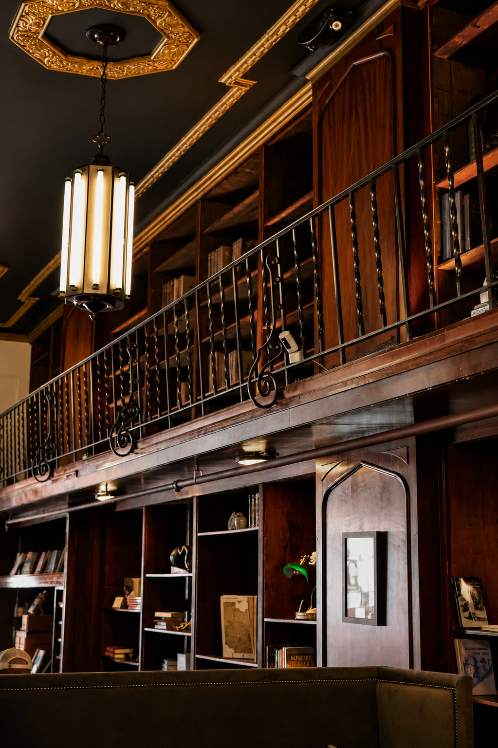 Original Art Deco light fixture and wrought iron mezzanine railing inside the 1929 Barker Building, home to The Reading Room in Omaha