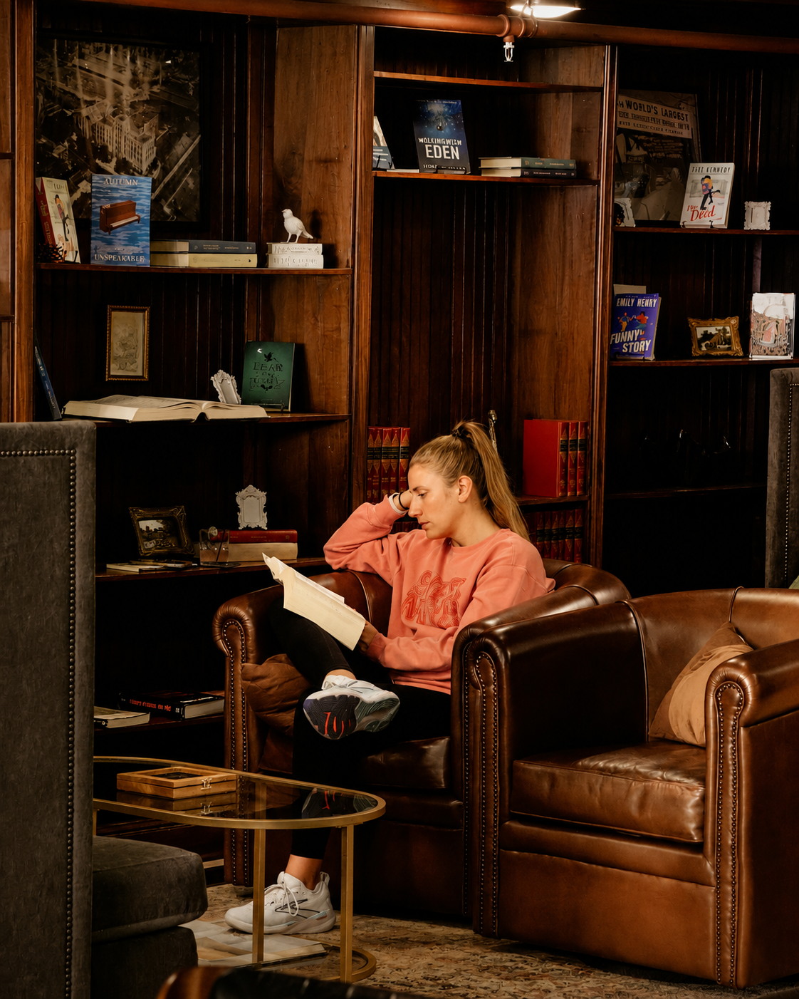 A customer reads in a leather club chair surrounded by mahogany bookshelves at The Reading Room in Omaha